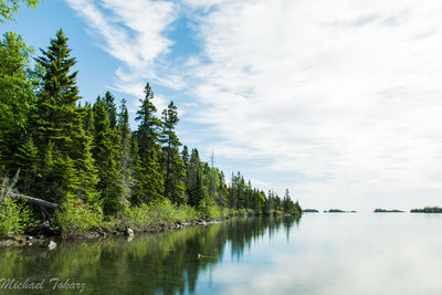 Blue skies and reflections on the calm waters at Three Mile