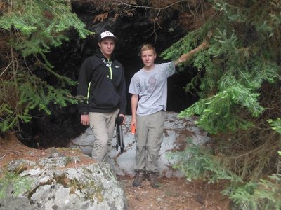 Myself and my cousin next to a big pile of snow in the middle of June